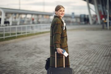 אישה עומדת עם מזוודה